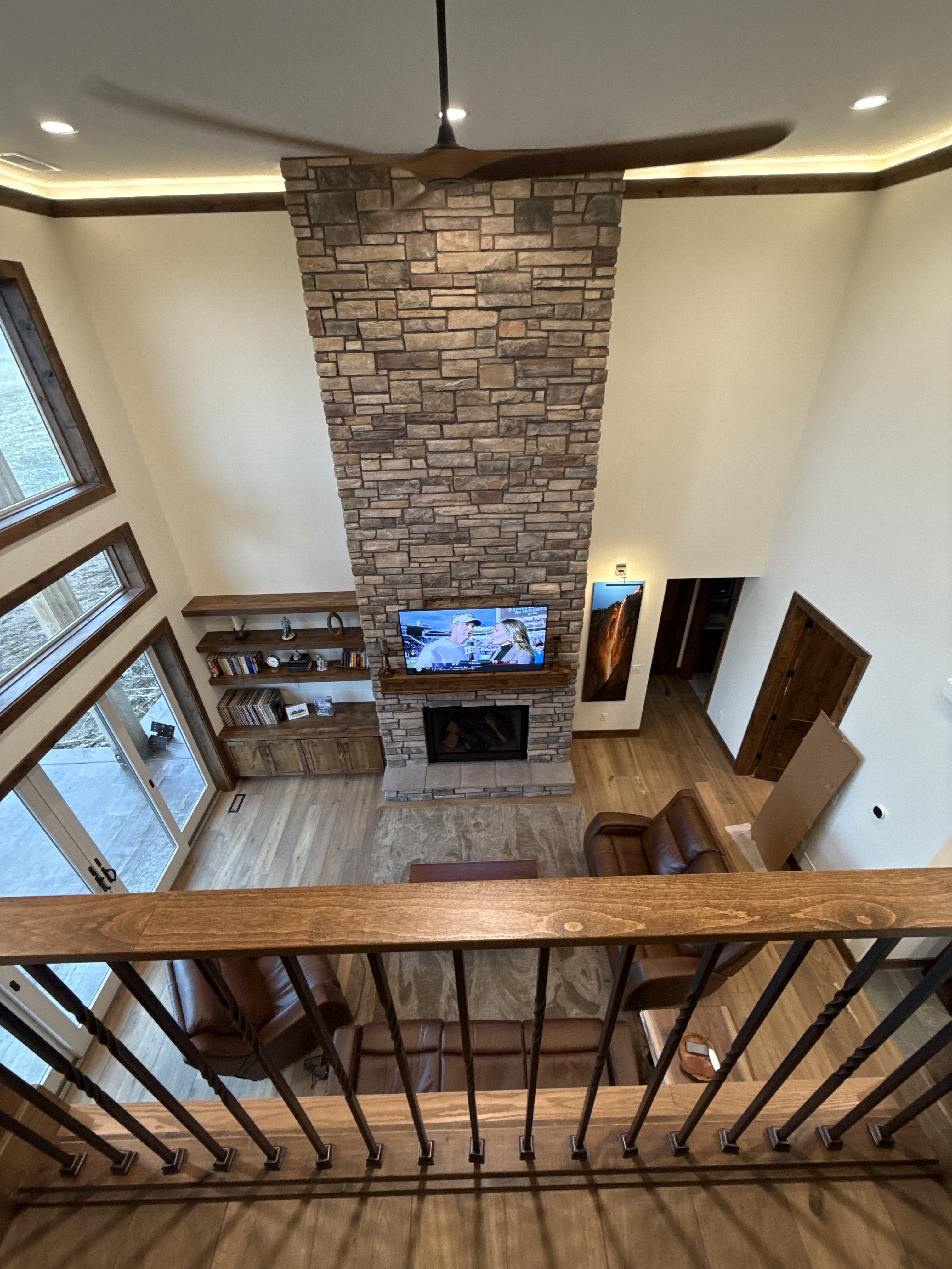 The Arbogast Home — full-height custom stone fireplace, built-in walnut shelving, and timber mantel. SwagerBuilds craftsmanship detail, Driggs, Idaho.
